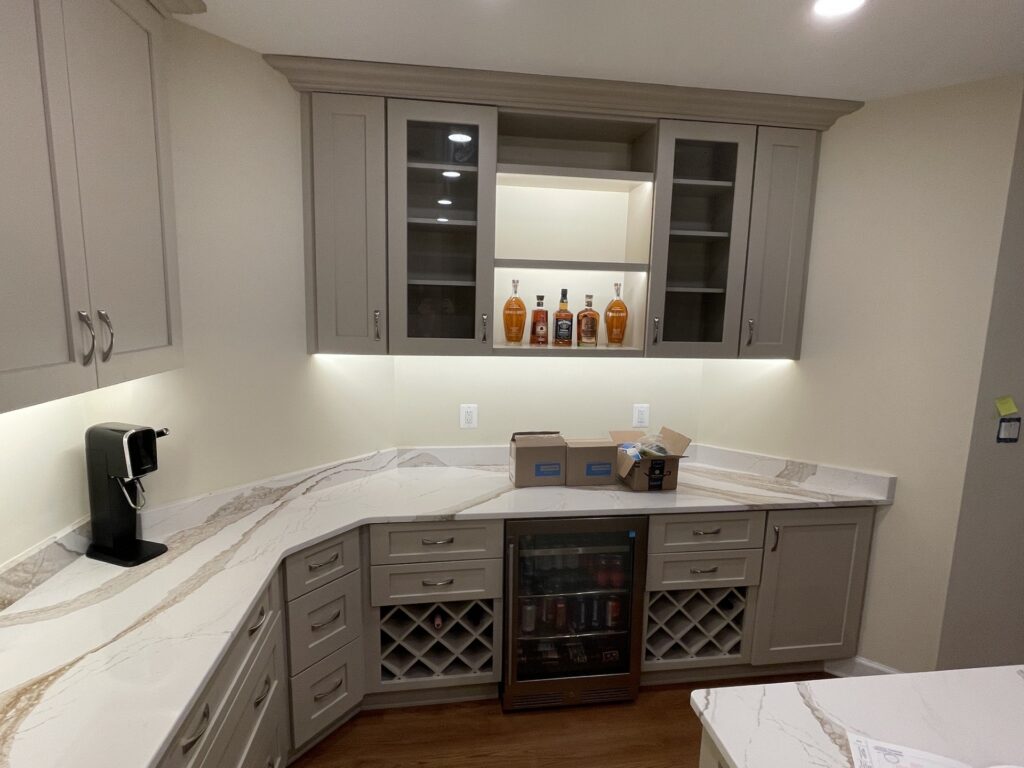 Basement kitchen bar area in McLean VA with custom cabinetry, wine storage, and under-cabinet lighting
