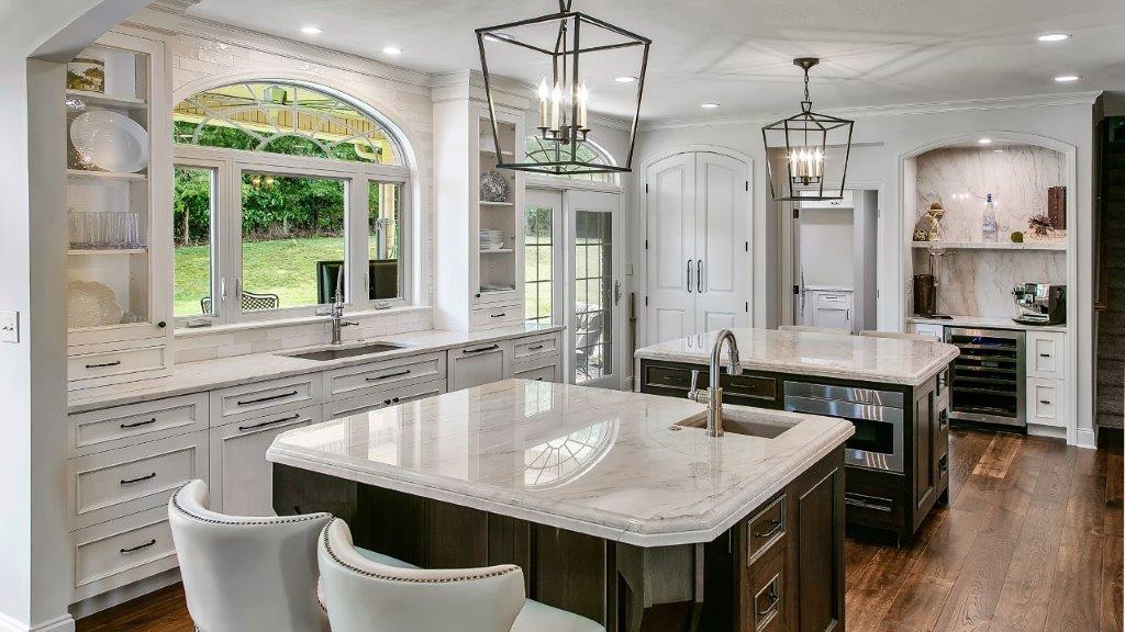 McLean VA kitchen remodel with double islands, custom white cabinetry, arched window, prep sink, and hardwood floors