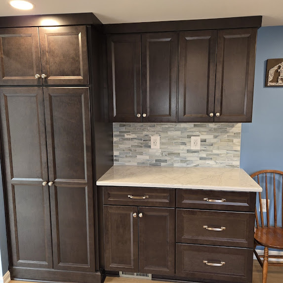 Kitchen remodel in Woodbridge VA with dark cabinetry, light countertop, and updated backsplash