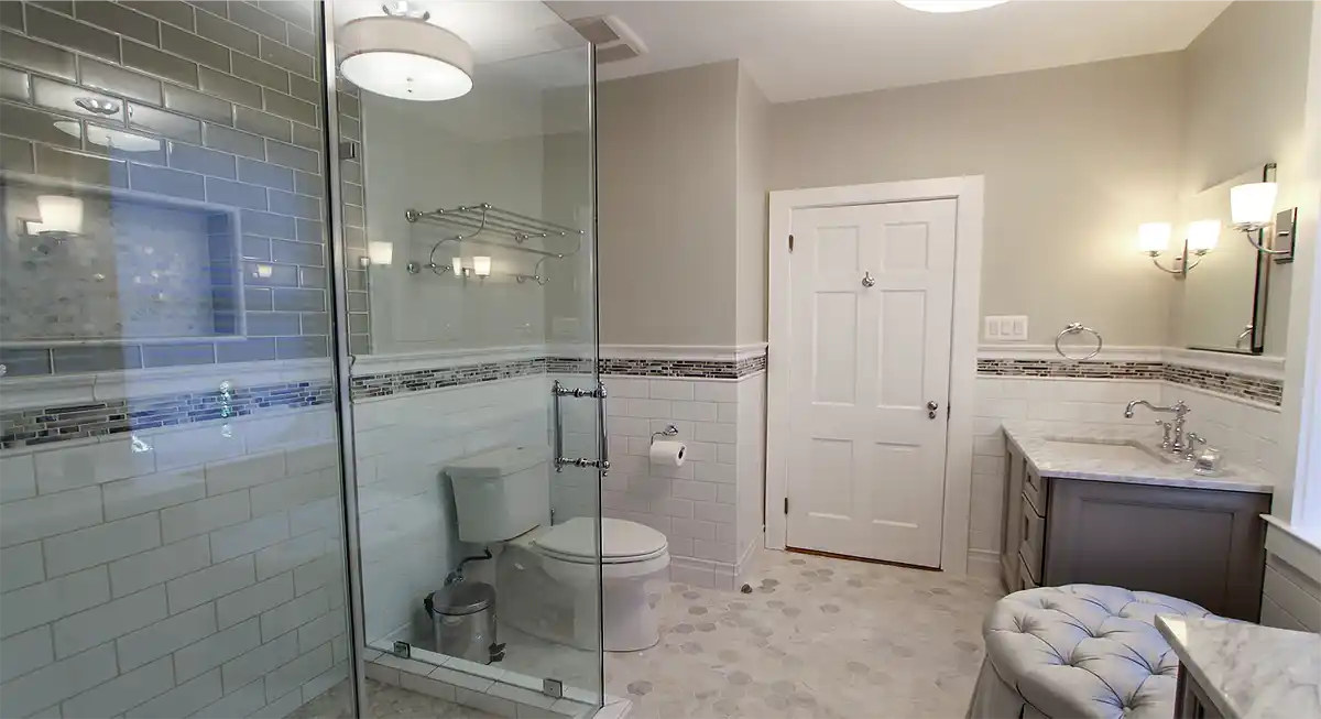 1930s Manassas VA bathroom remodel with glass-enclosed tile shower, gray vanity, marble-look countertop, and mosaic accent tile