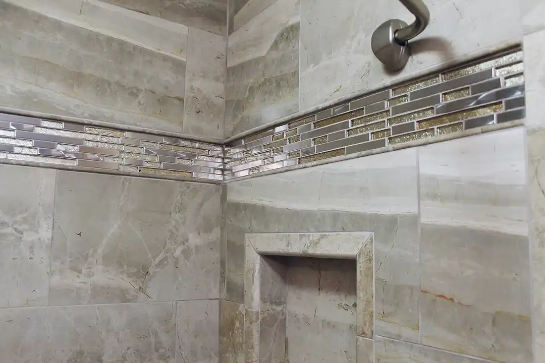 Gainesville VA bathroom remodel with stone-look shower tile, mosaic accent band, recessed shower niche, and brushed nickel shower fixture