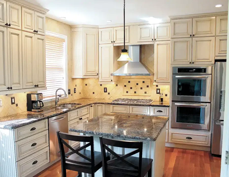 Gainesville VA kitchen remodel with cream cabinets, granite island, tile backsplash, stainless appliances, and built-in double oven