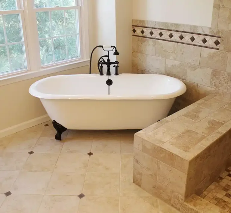 Gainesville VA primary bathroom remodel with clawfoot tub, walk-in tile shower, bench wall, decorative accent tile, and dark bronze tub filler