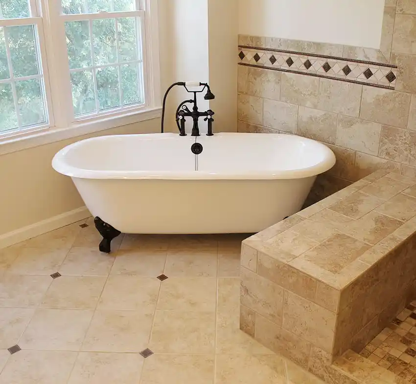 Gainesville VA primary bathroom remodel with clawfoot tub, walk-in tile shower, bench wall, decorative accent tile, and dark bronze tub filler