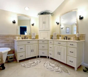 Gainesville VA primary bathroom remodel with corner double vanity, cream cabinetry, arched mirrors, freestanding tub, and tile wainscoting