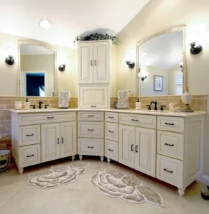 Gainesville VA primary bathroom remodel with corner double vanity, cream cabinetry, arched mirrors, freestanding tub, and tile wainscoting
