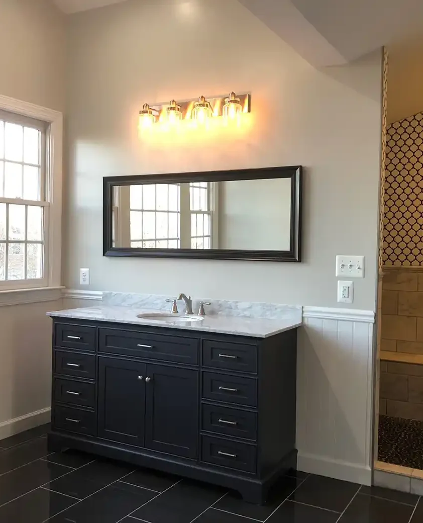 Manassas VA primary bathroom remodel with dark vanity, marble-look countertop, freestanding tub, tall windows, and patterned tile shower