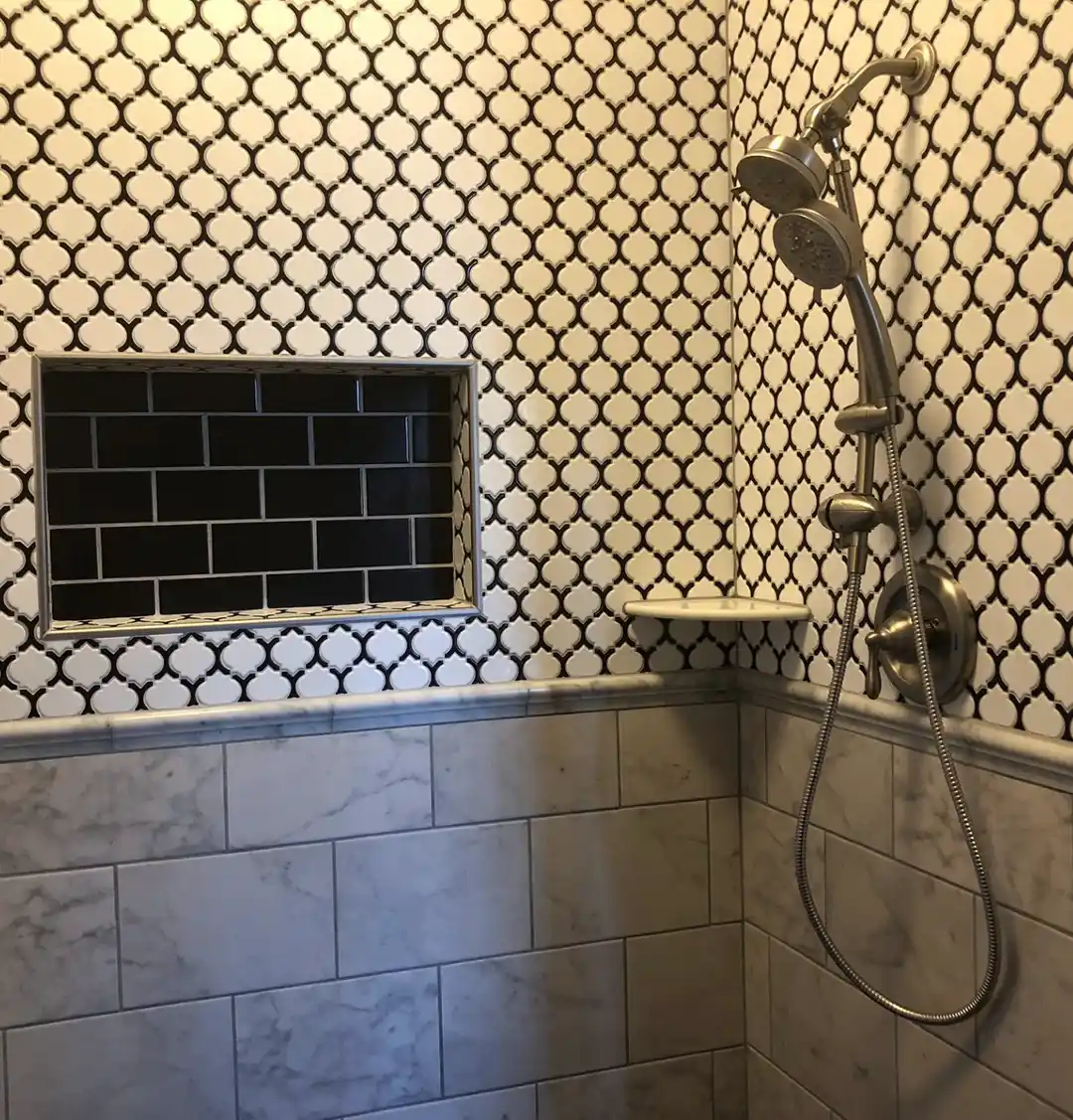 Manassas VA primary bathroom remodel with patterned tile shower, black subway tile niche, marble-look lower wall tile, and brushed metal shower fixtures