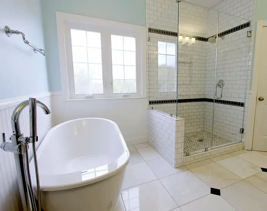 Manassas VA bathroom remodel with glass-enclosed white subway tile shower, black accent tile, and classic mosaic shower floor
